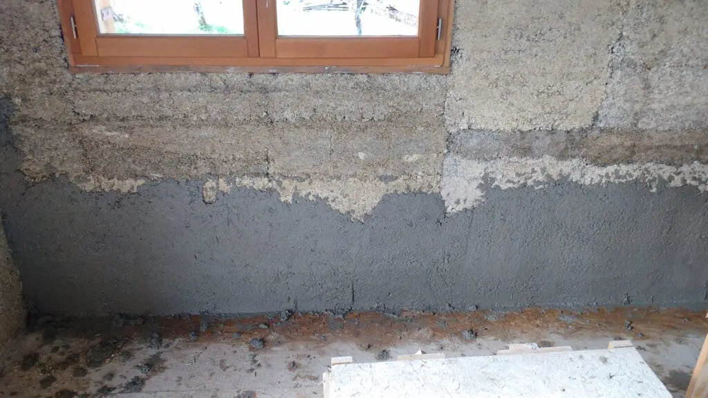 Pictured is lime/hemp plaster being applied to a hempcrete wall
