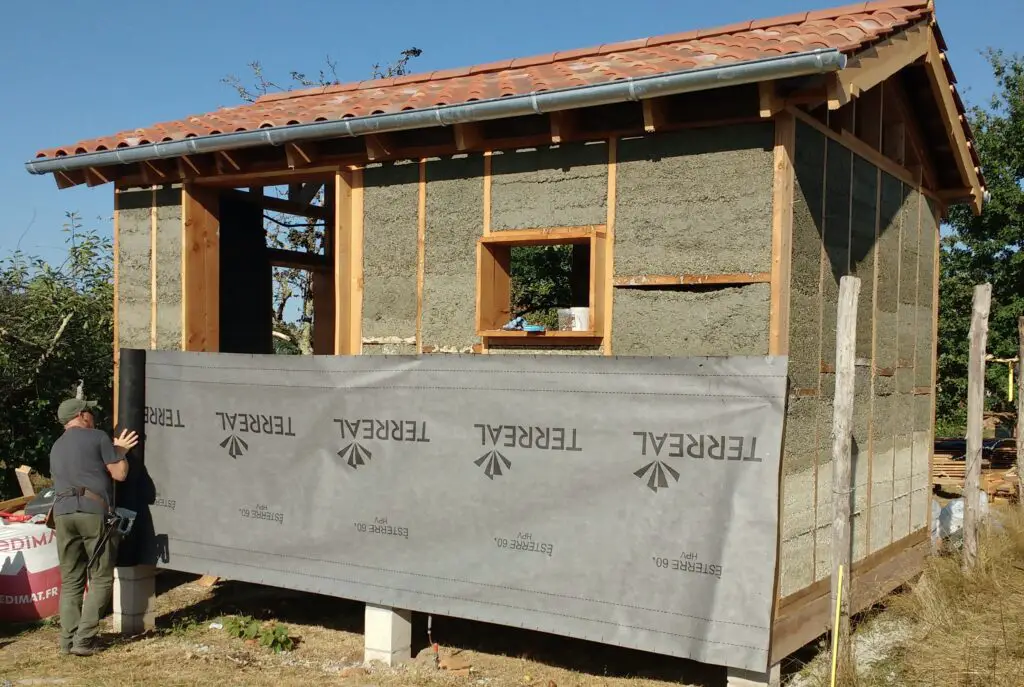 Pictured is the rainscreen being stapled to the tiny house walls